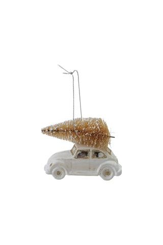 Decorative ornament of a small car with a Christmas tree on top against a white background