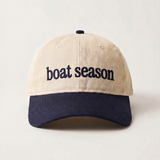 Beige and navy cap with 'boat season' text on a light gray background