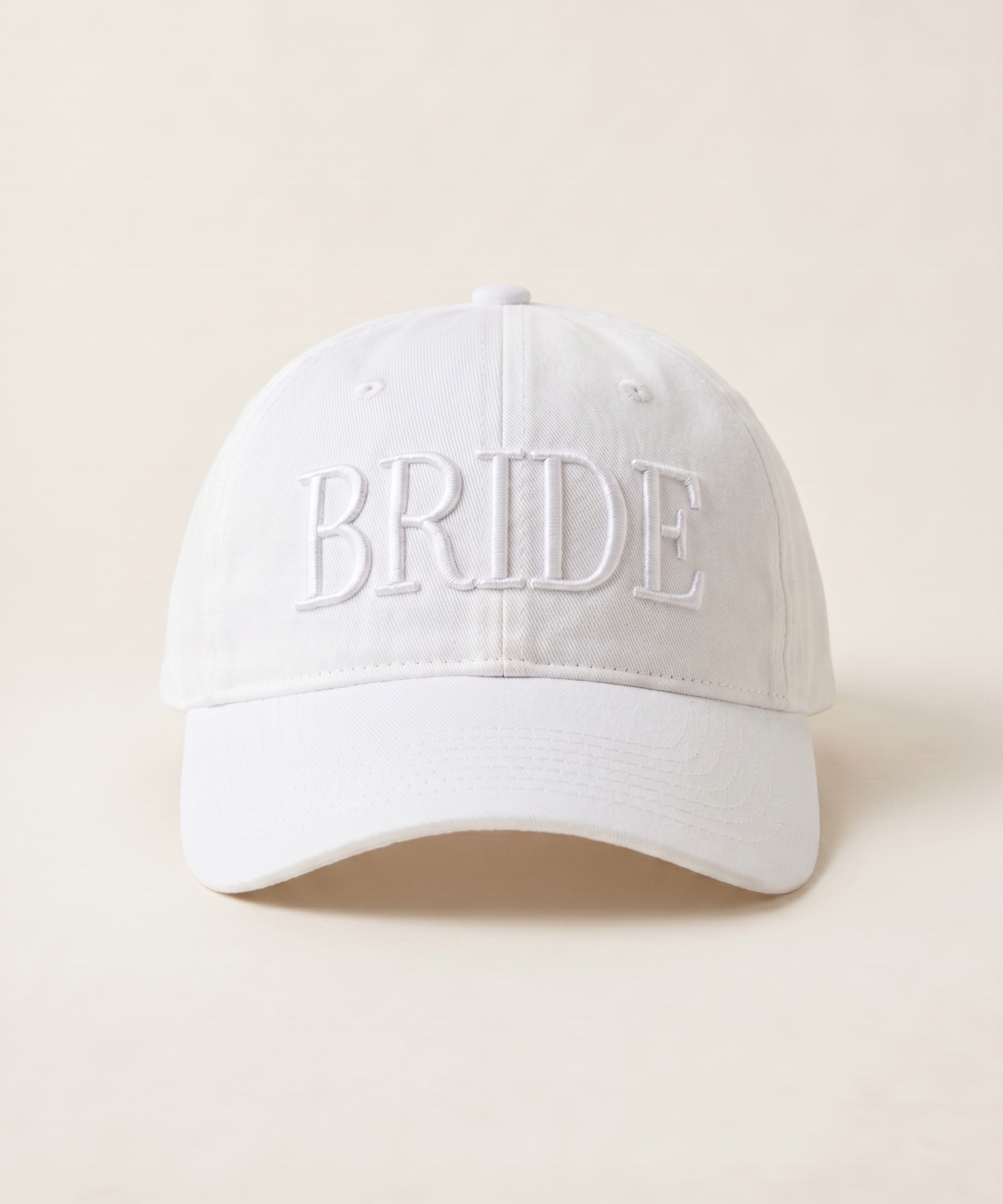 White cap with 'BRIDE' embroidery on a beige background