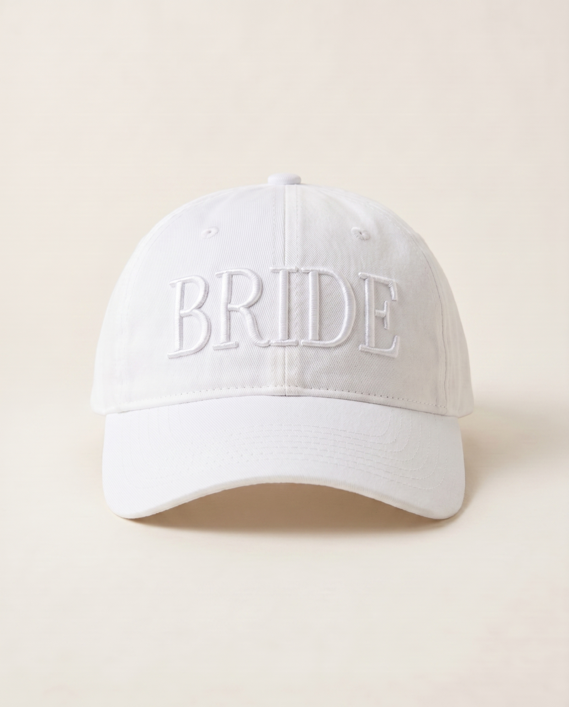 White cap with 'BRIDE' embroidery on a beige background