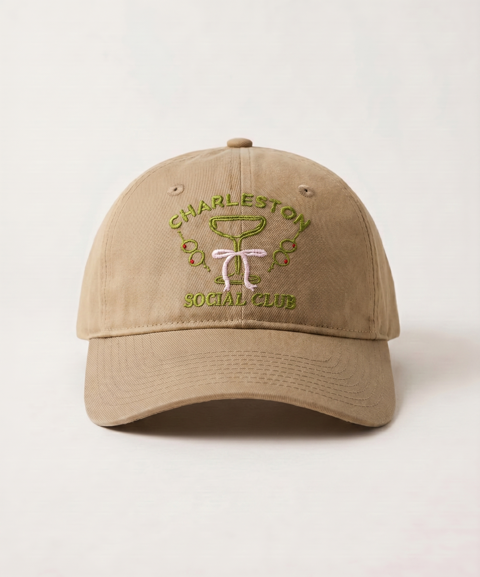 Beige cap with 'Charleston Social Club' embroidery on a light beige background
