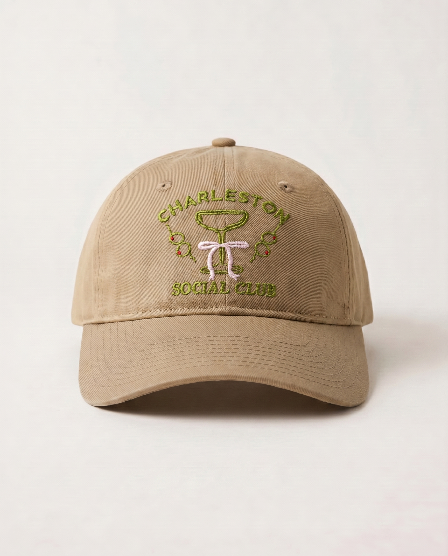 Beige cap with 'Charleston Social Club' embroidery on a light beige background