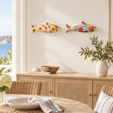Yellow floral and multicolor stoneware fish displayed above a dining room sideboard
