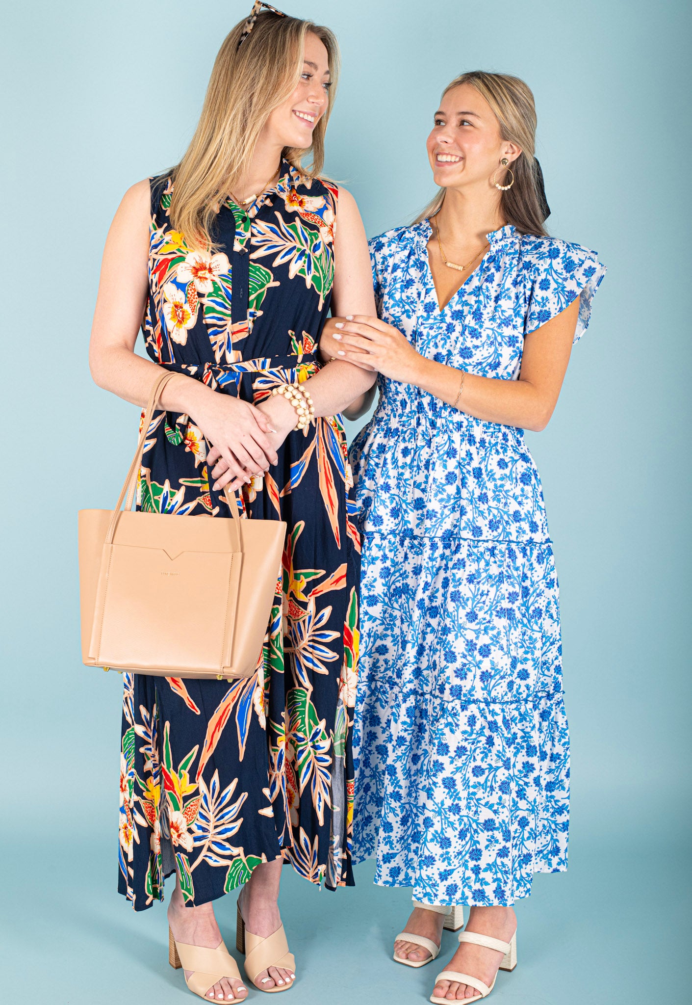 Two woman standing together in floral maxi dresses