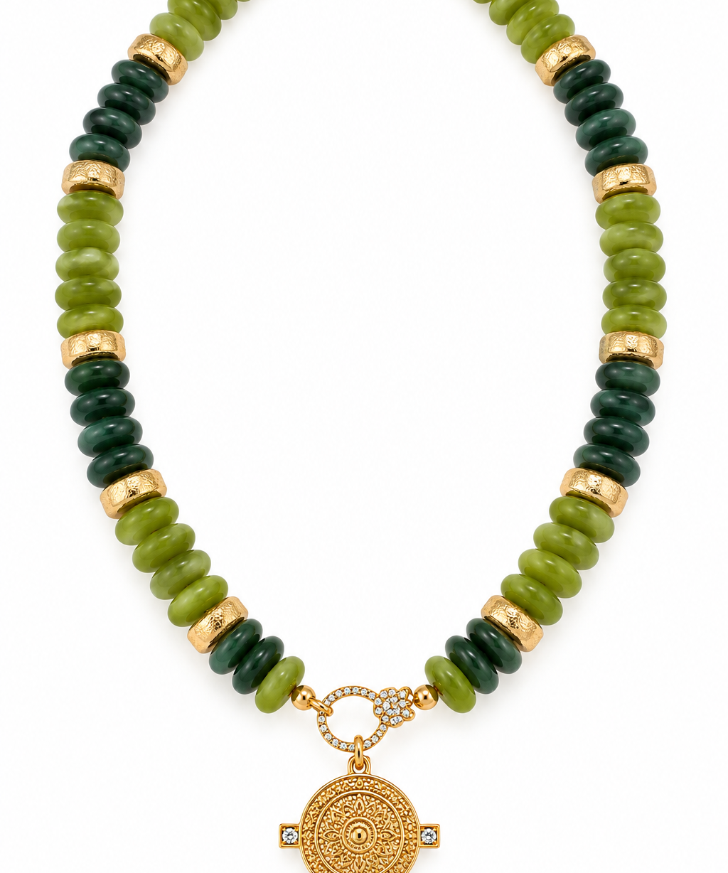 Green coastal medallion beaded necklace featuring olive and dark forest green acrylic rondelle beads, textured gold-tone spacers, and an ornate gold medallion pendant, 17 inches long.