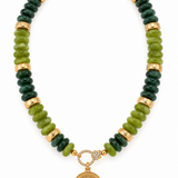 Green coastal medallion beaded necklace featuring olive and dark forest green acrylic rondelle beads, textured gold-tone spacers, and an ornate gold medallion pendant, 17 inches long.