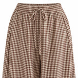 Close-up of brown gingham fabric, elastic waistband and matching drawstring