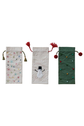 Three decorative drawstring bags with festive designs on a white background