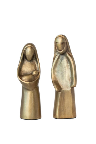 Two brass statues of a seated and standing figure on a white background