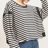 Women's black and cream striped cropped long sleeve top with a relaxed silhouette, dropped shoulders, and contrasting ribbed cuffs.
