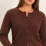 Women's chocolate brown button-front knit cardigan with crew neckline, matching buttons, and ribbed trim, styled with jeans.