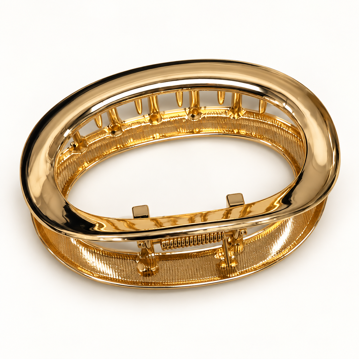 Gold oval claw hair clip on a white background
