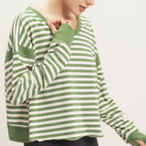 Women's green and cream striped long sleeve top featuring a relaxed fit, wide crew neckline, dropped shoulders, ribbed cuffs, and cropped hem.