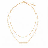 Layered gold sideways cross necklace studio photo
