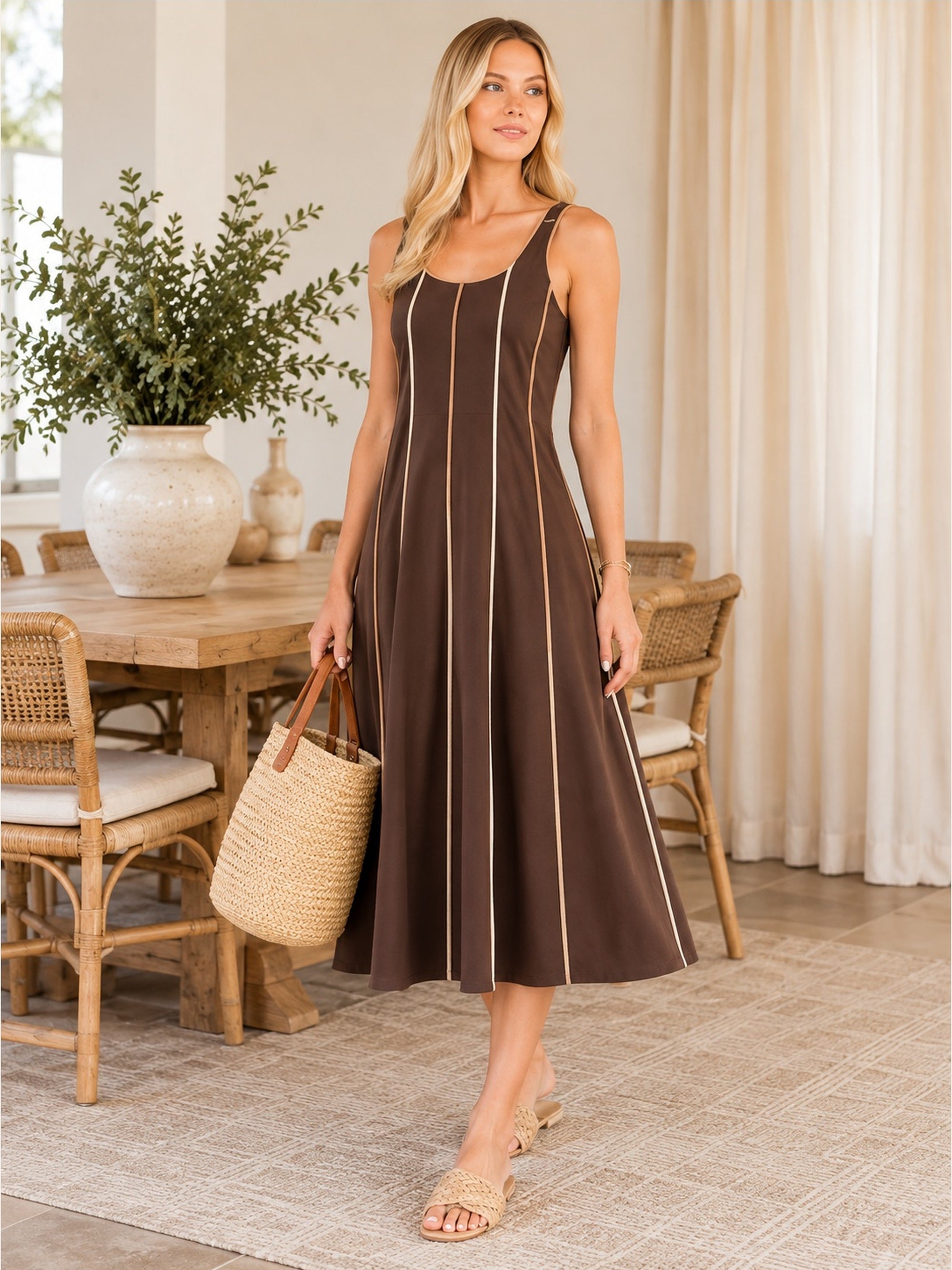 Full-length model wearing chocolate brown contrast piping midi dress in coastal interior
