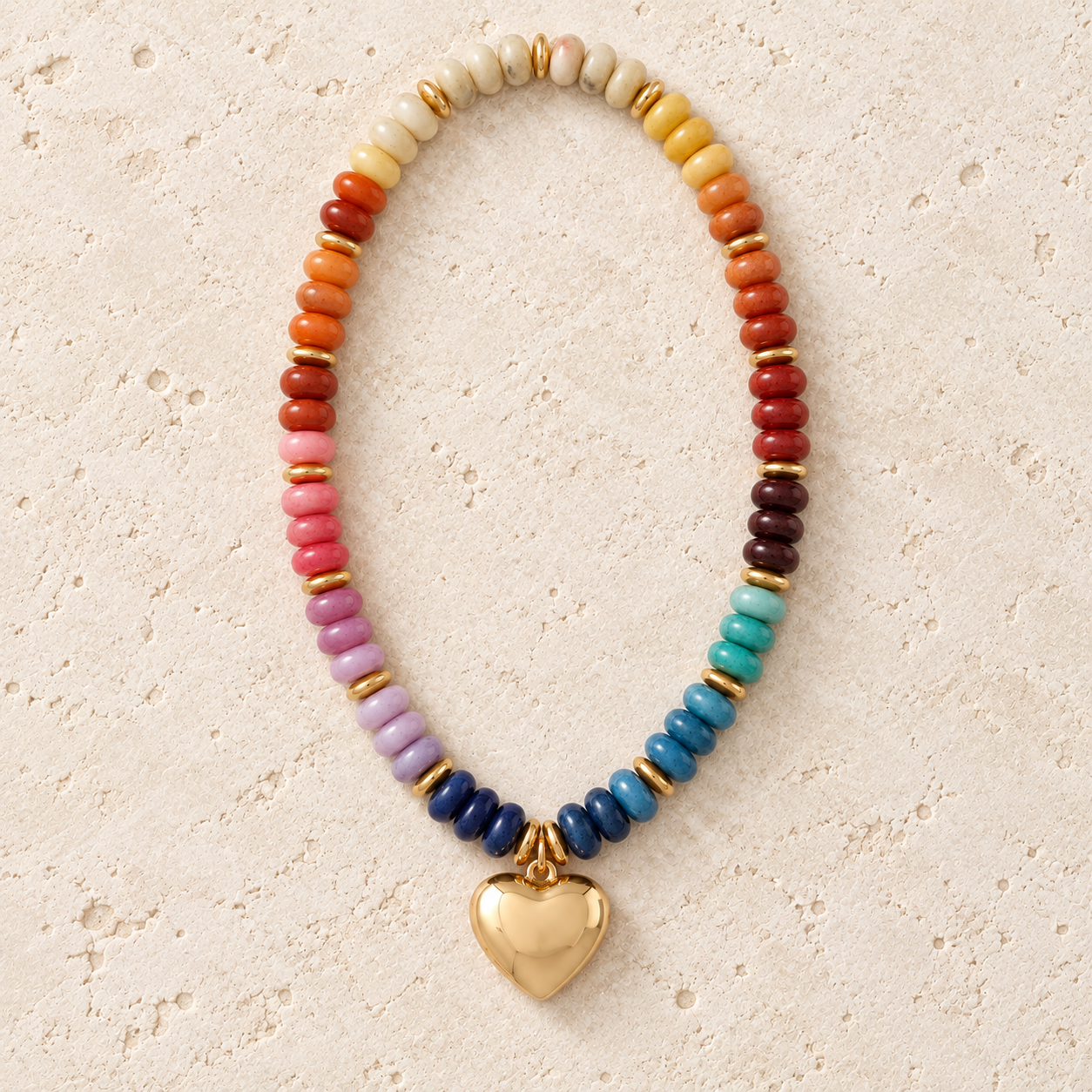 Chunky rainbow beaded necklace with gold-tone spacers and a polished heart pendant