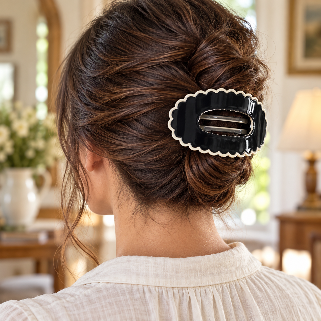 Black scalloped oval claw hair clip worn in a brunette updo