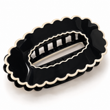 Black scalloped oval claw hair clip on a white background