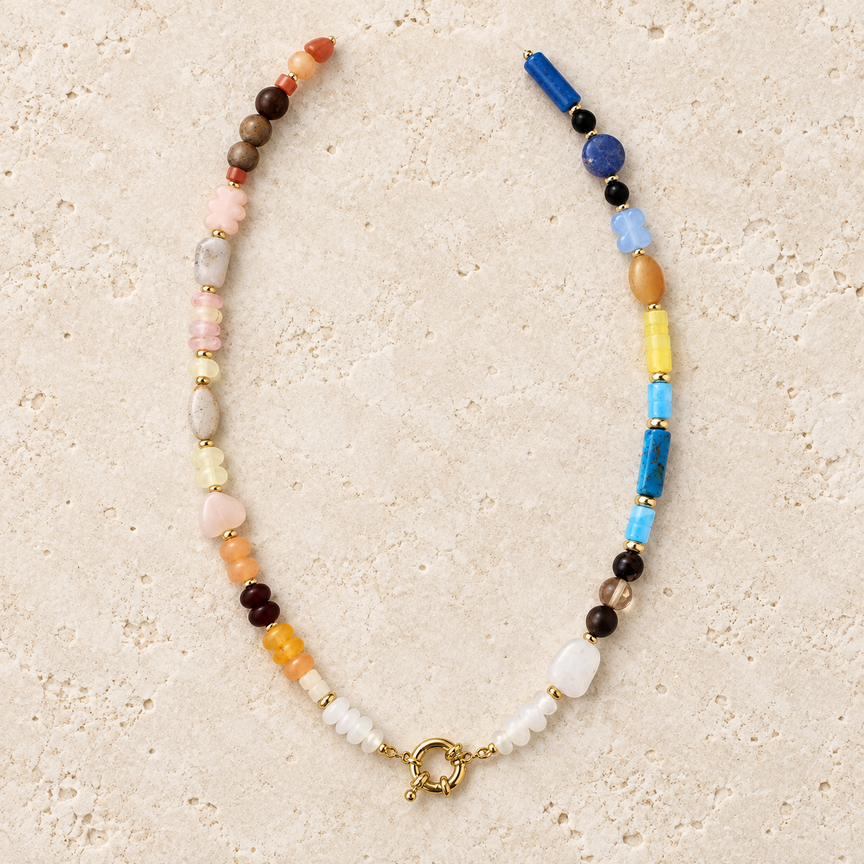 Asymmetrical multicolor beaded necklace with blue, blush, amber and cream beads and a gold-tone toggle clasp.