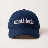Navy blue cap with 'unathletic' text on a light beige background